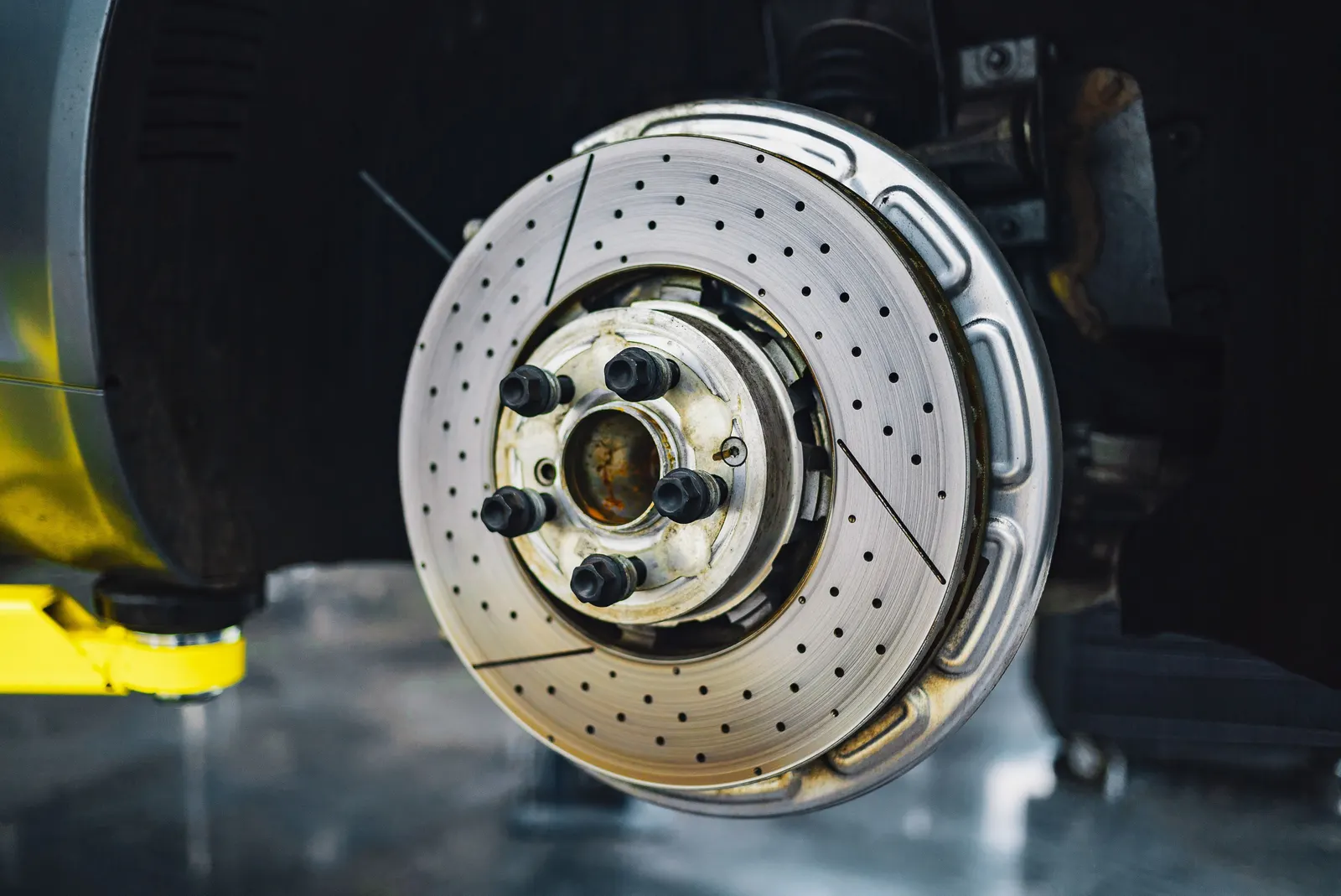 จานเบรกและชุดเบรกของรถที่ถอดล้อออก มองเห็นผิวจานและตำแหน่งผ้าเบรก